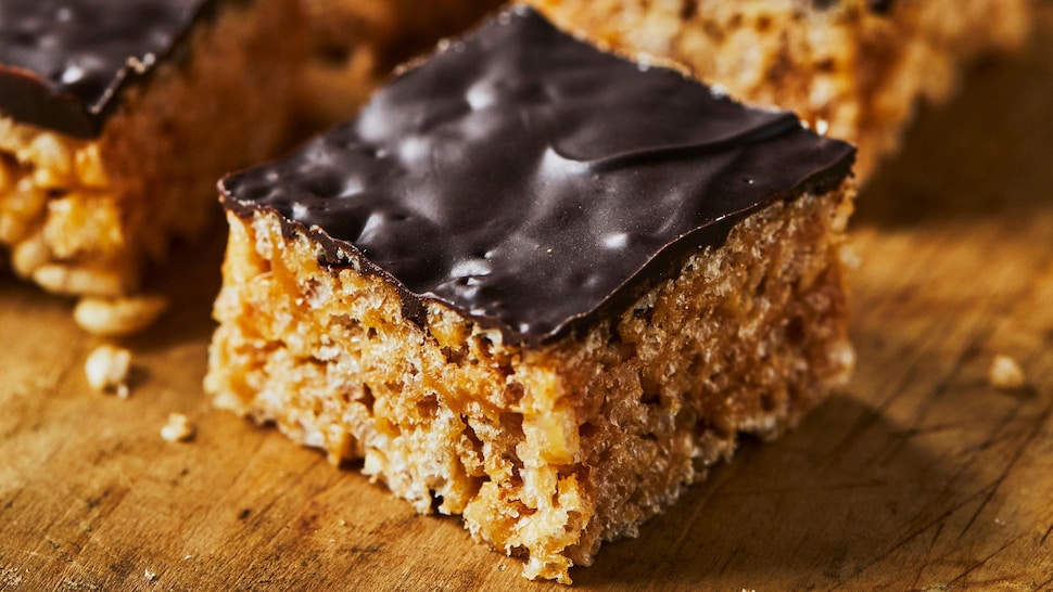 Des carrés aux Rice Krispies choco-arachides sur une planche de bois.