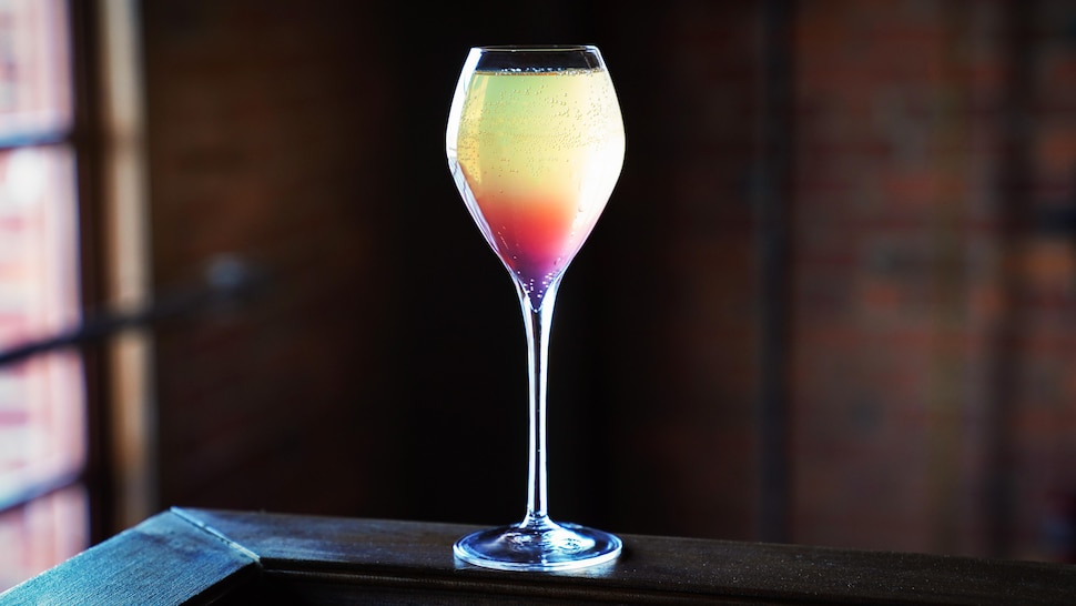 Un cocktail avec plusieurs étages de couleurs passant par le vert, le jaune, le rouge et le mauve.
