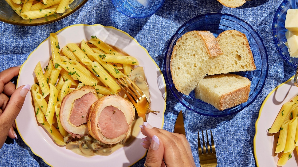 Un plat de coq au porc servi avec des pâtes aux herbes fraîches et une sauce aux champignons.