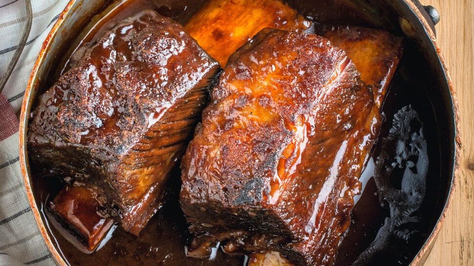 Des côtes levées bien braisées dans une casserole.