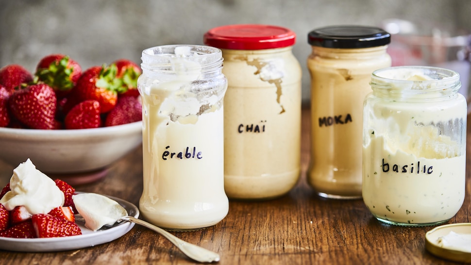 Quatre pots en verre contenant de la crème fouettée à l'érable, chaï, au basilic et au moka. 
