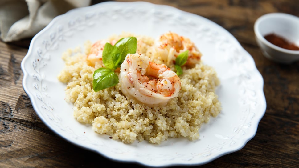 Trois crevettes déposées sur du quinoa.