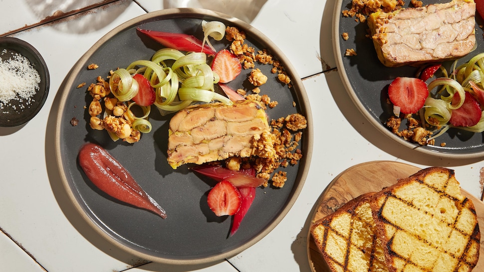 Une assiette de foie gras accompagné de rhubarbe, d'une gelée fraise et d'un crumble aux noisettes.