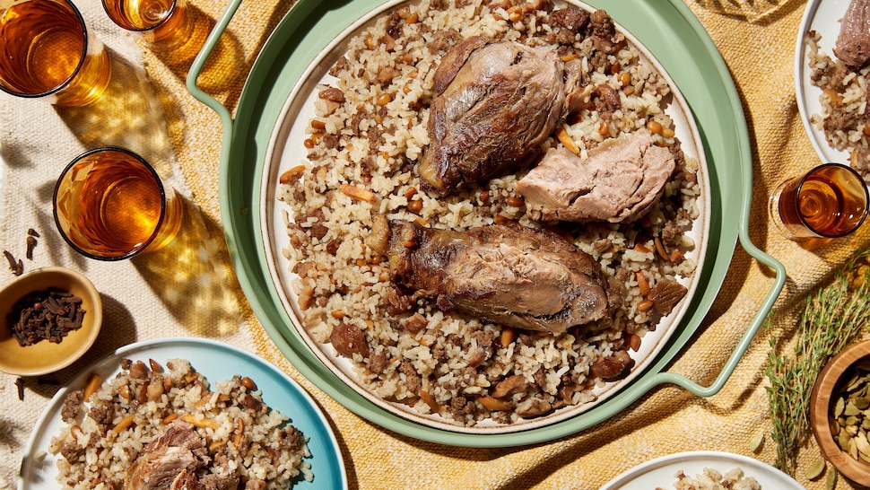 Du jarret de veau braisé servi sur un lit de riz contenant de la viande hachée, des noix torréfiées et des marrons grillés.