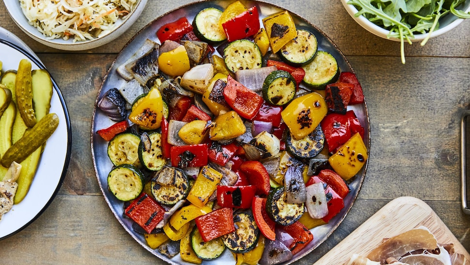 Une grande assiette noire avec des légumes grillés.