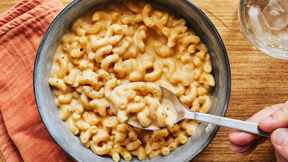 Un bol de macaroni au fromage avec une cuillère dedans. 