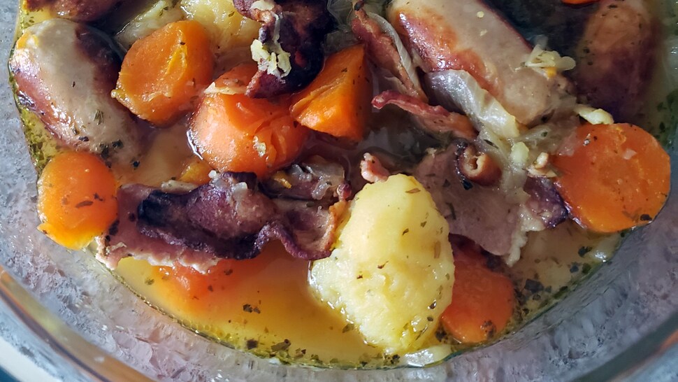 Un plat de ragoût de pommes de terre, de bacon et de saucisses.