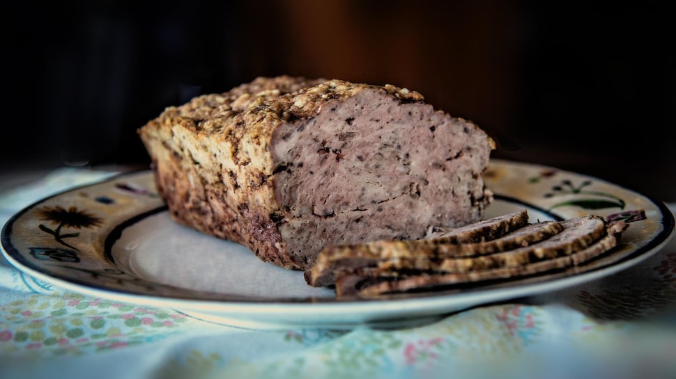 Un pain de viande tranché dans une assiette.
