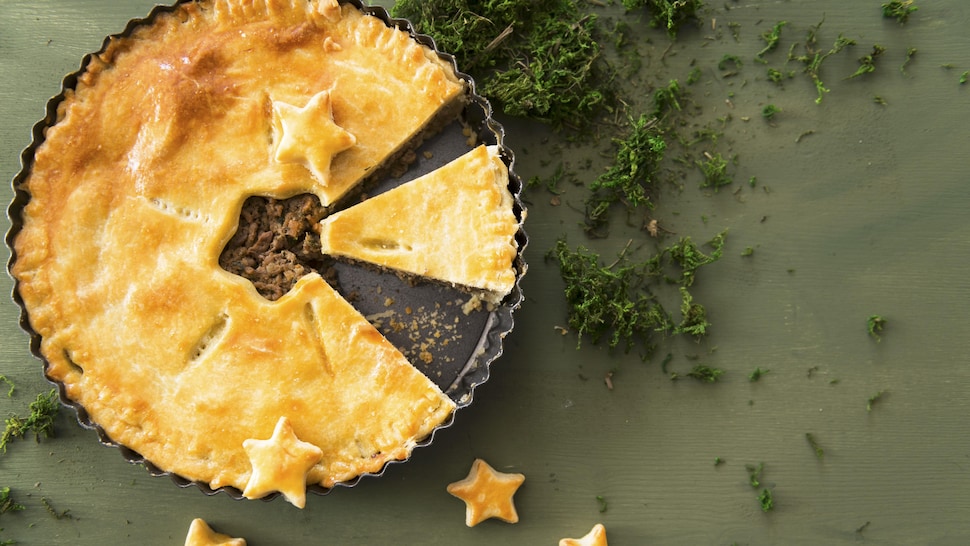 Une tourtière tranchée et servie dans un moule.