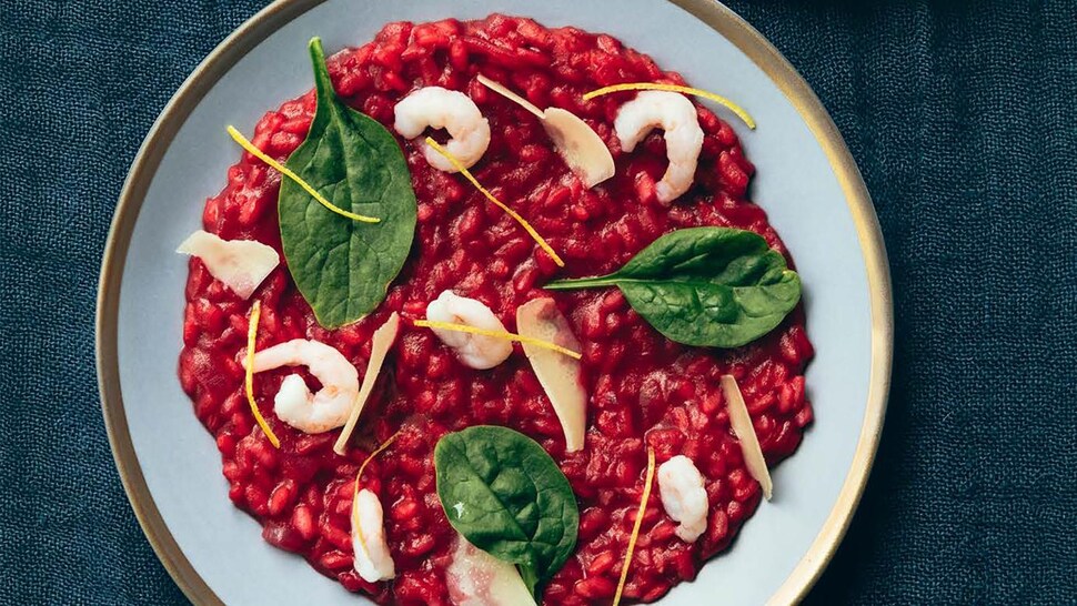Des assiettes de risotto sanguin avec des crevettes et des épinards.
