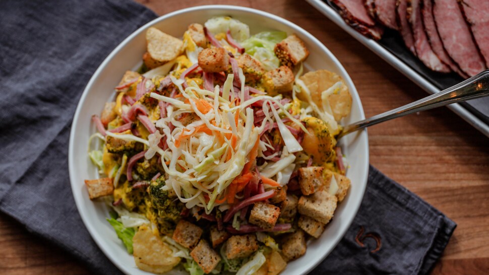 Un bol de salade de viande fumée, de salade de chou et de croûtons.