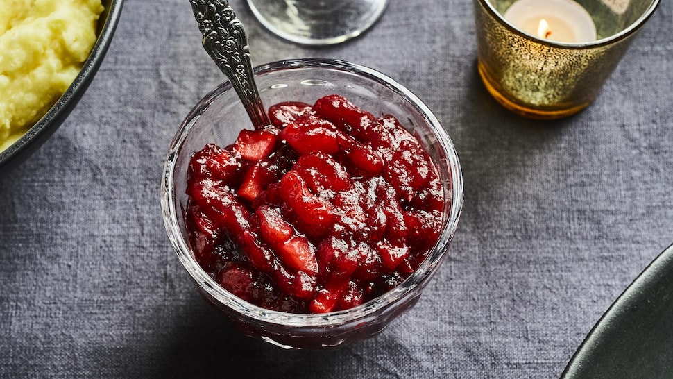 Sauce aux canneberges et aux pommes dans un bol avec une cuillère.