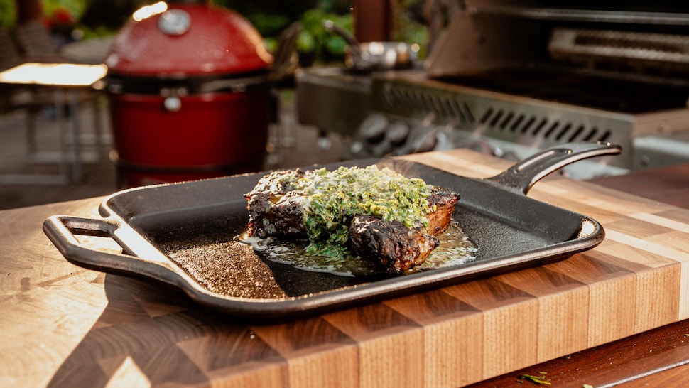 Un steak grillé au BBQ servi avec du beurre aux herbes.