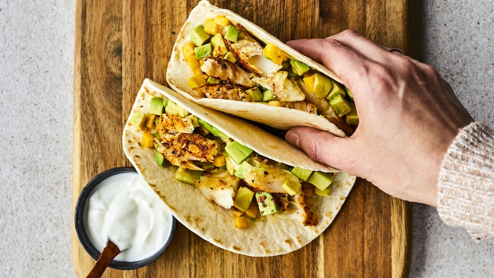 Deux tacos de poisson sur une table.