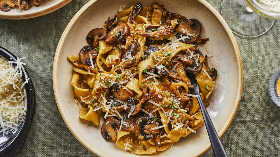 Un bol de tagliatelles aux champignons sur une table.