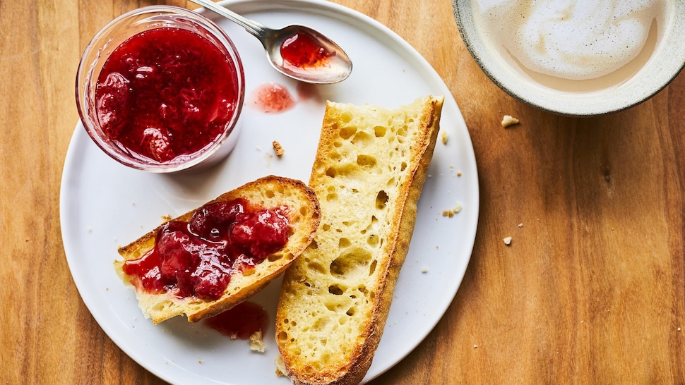 Tartinade aux fraises réduite en sucre sur un pain dans une assiette.