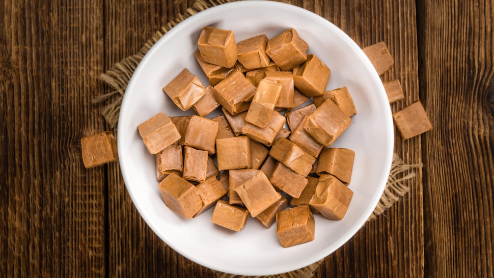 Des bonbons bruns en cubes dans une assiette.