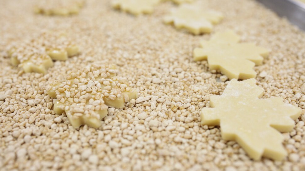 Chaque biscuit est pressé dans une plaque à biscuit contenant des milliers de pépites d'érable. 