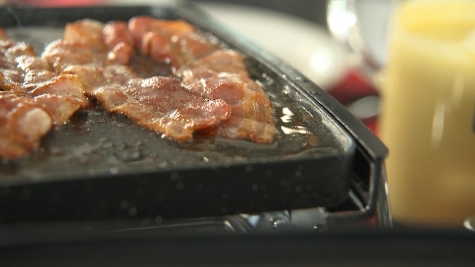 Du bacon et du gras de bacon sur un four à raclette.