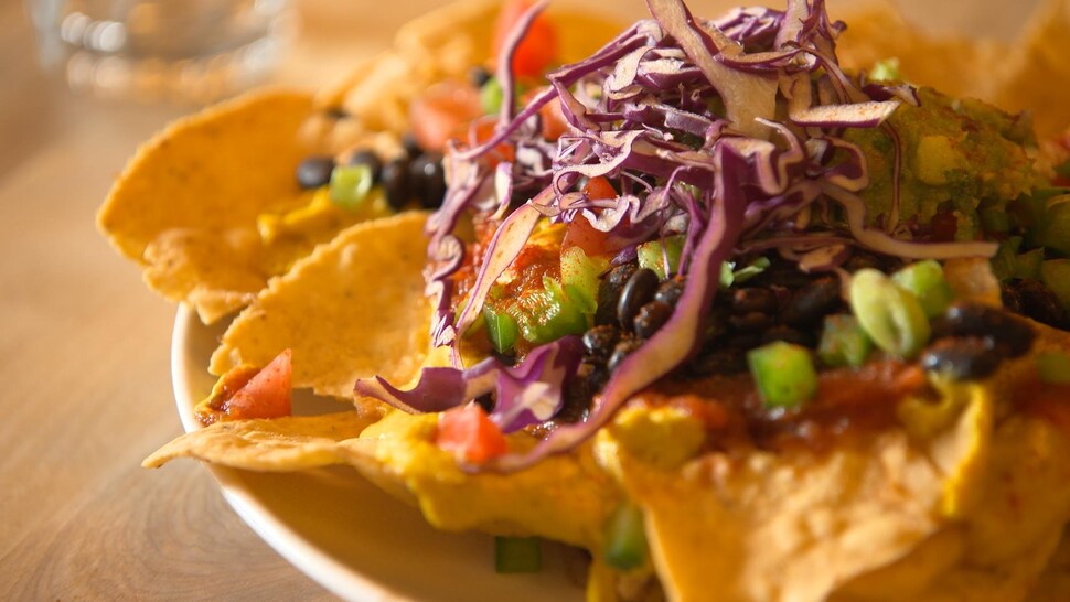 Des nachos avec une sauce aux graines de tournesol et des légumes.