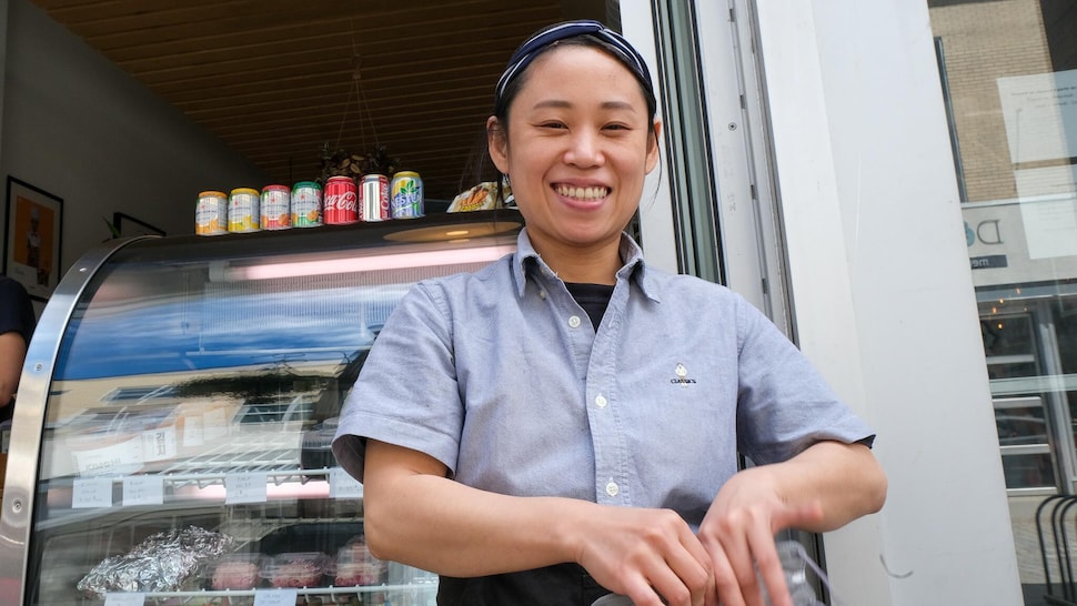 Une femme regarde la caméra en souriant. 