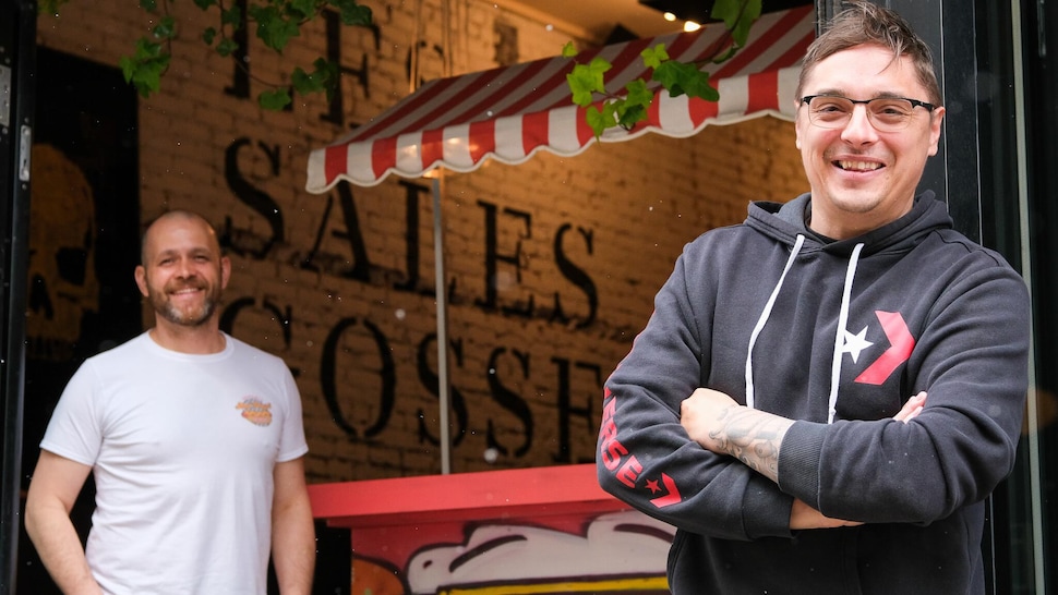 Deux hommes d'affaires devant leur restaurant. 