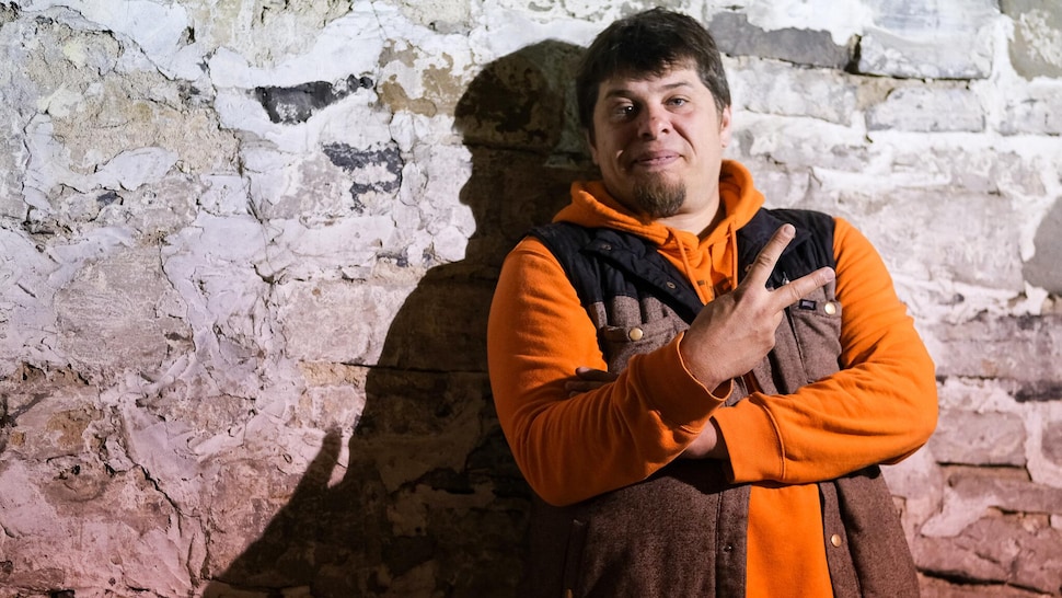 Le chef Stéphane Modat pose devant un mur de pierre. 