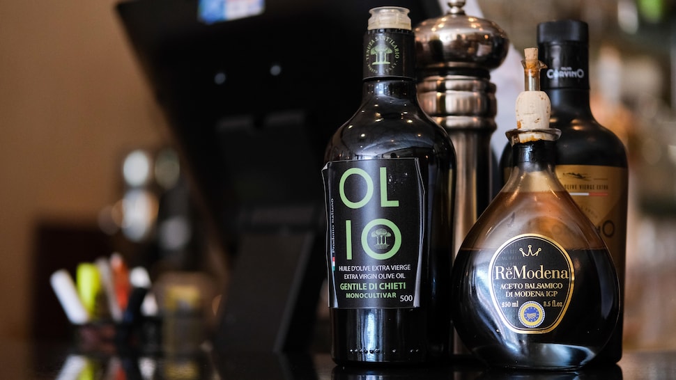 Une bouteille d'huile d'olive et de vinaigre balsamique sur un comptoir. 