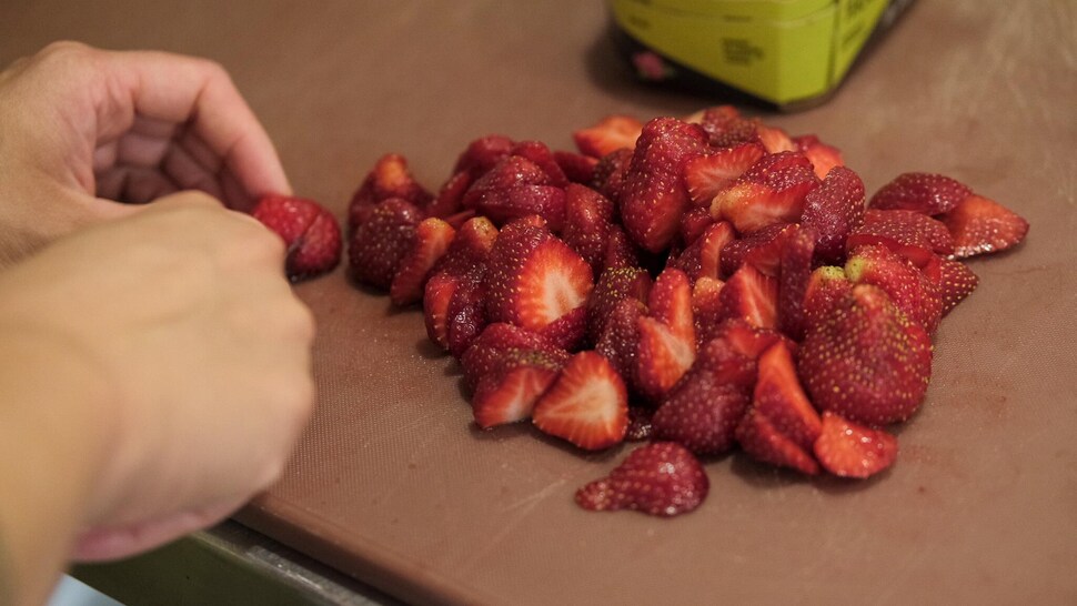Des fraises fraîchement coupées sur une planche en bois. 