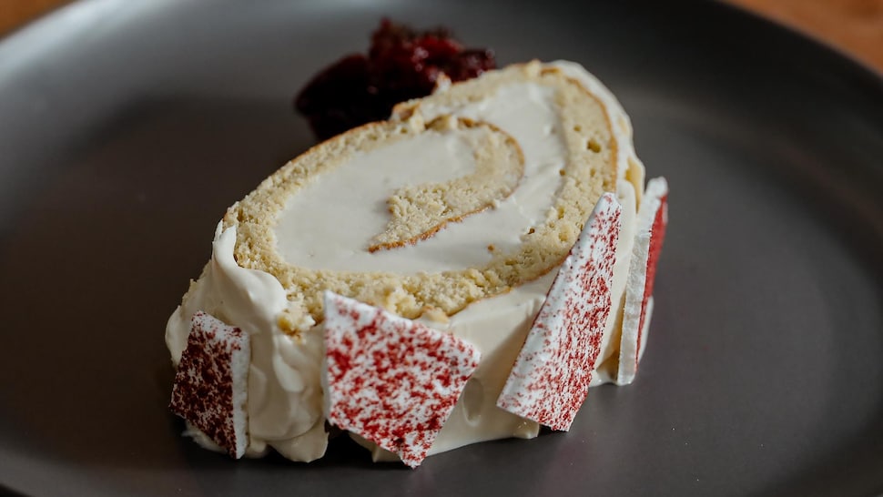 Un morceau de bûche de Noël, chaï et agrumes, servie avec une compote de canneberges