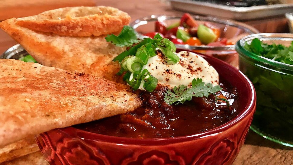 Un bol de chili avec des tortillas.