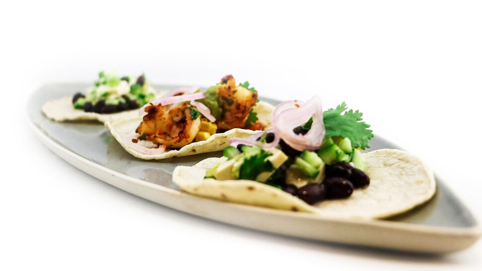 Trois tacos garnis dans un plat.