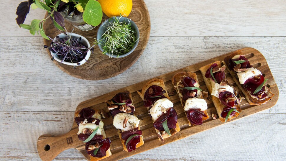 De la mousse de fromage frais aux herbes et rubans de betteraves servie sur petits pains grillés.