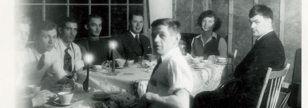 Henri Lanctin avec six hommes et une femme, assis à une table à manger.