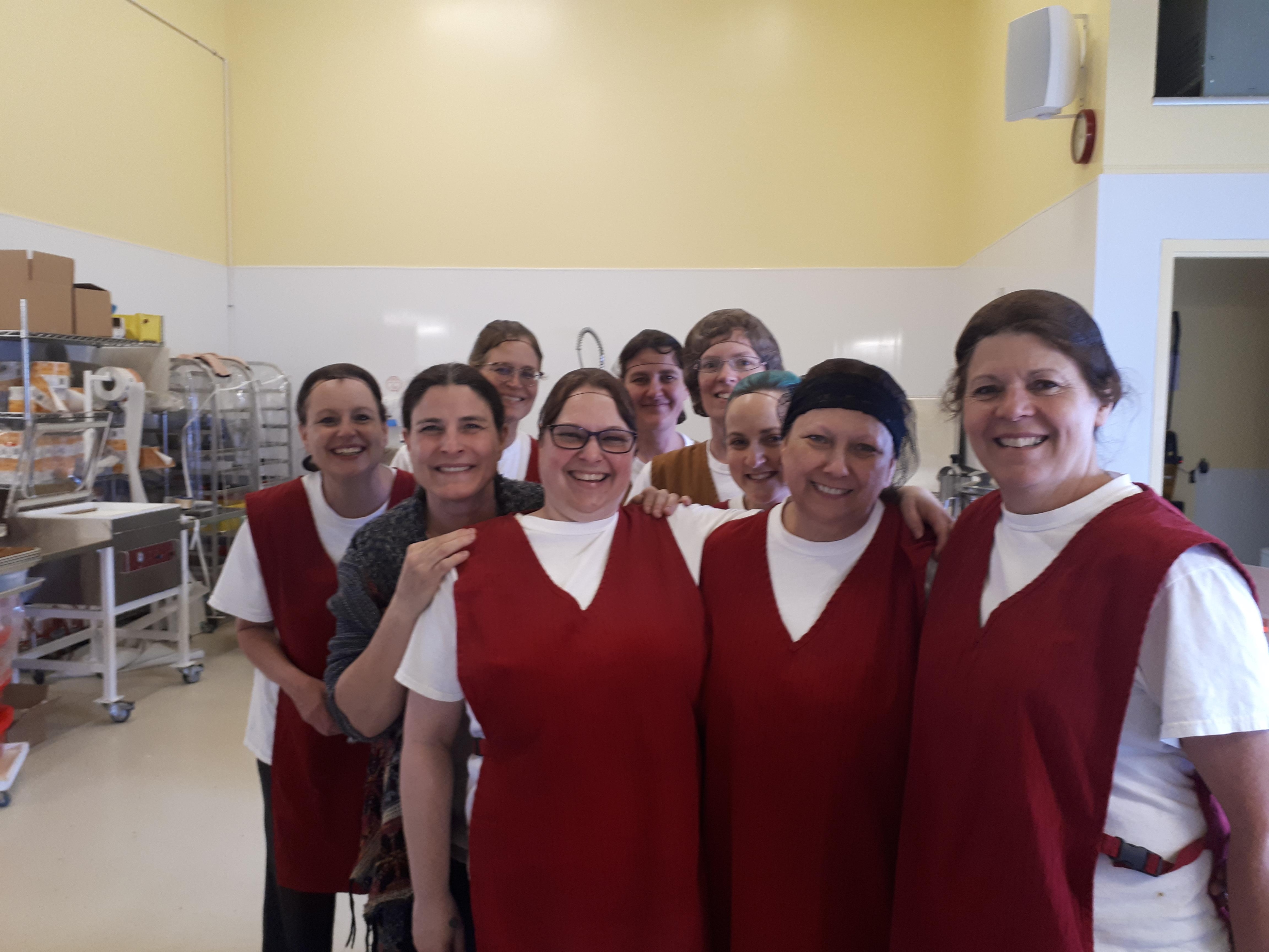 Neuf femmes sourient à la caméra dans une cuisine industrielle