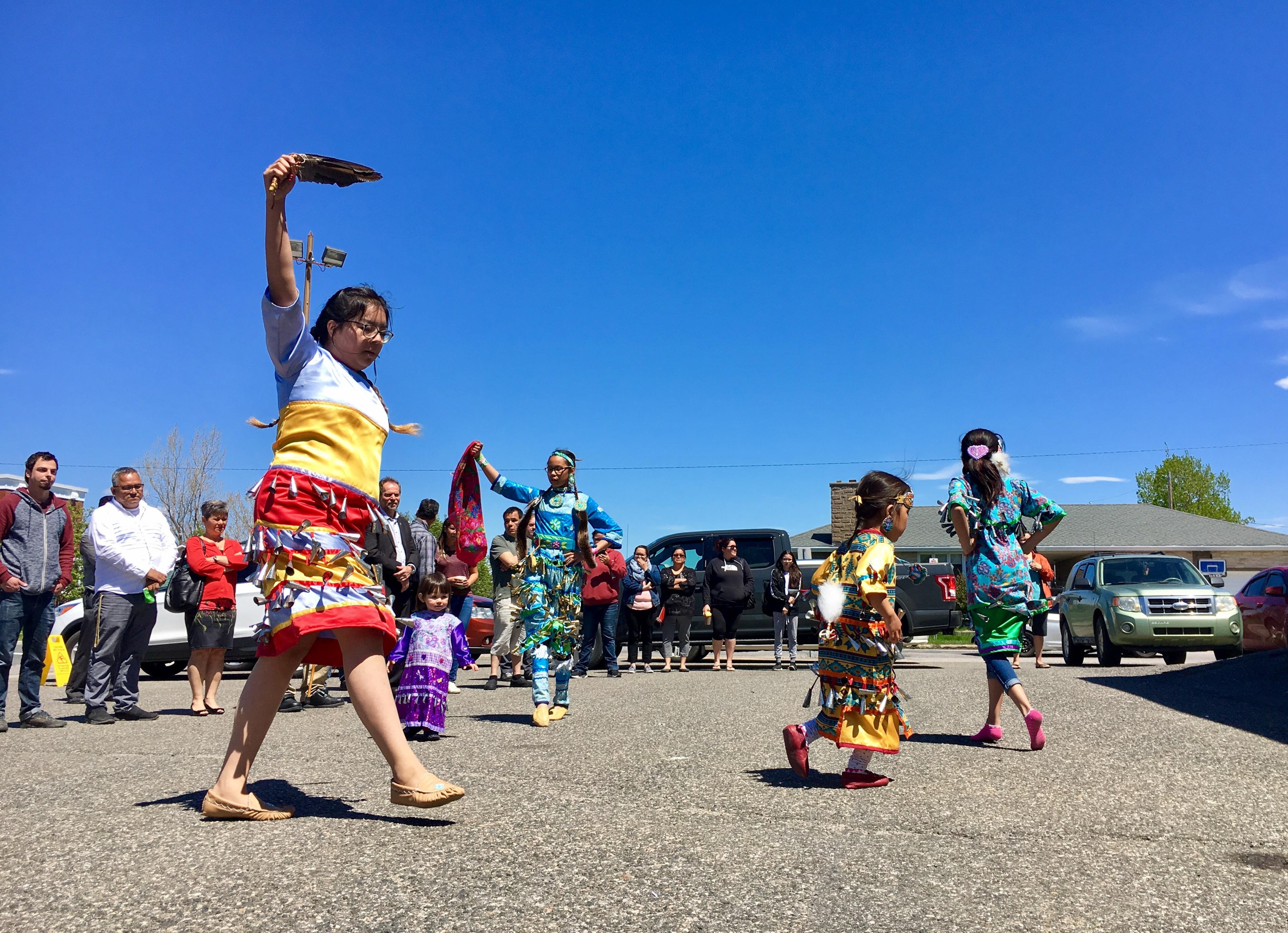Une jeune femme danse en habit traditionnel autochtone.