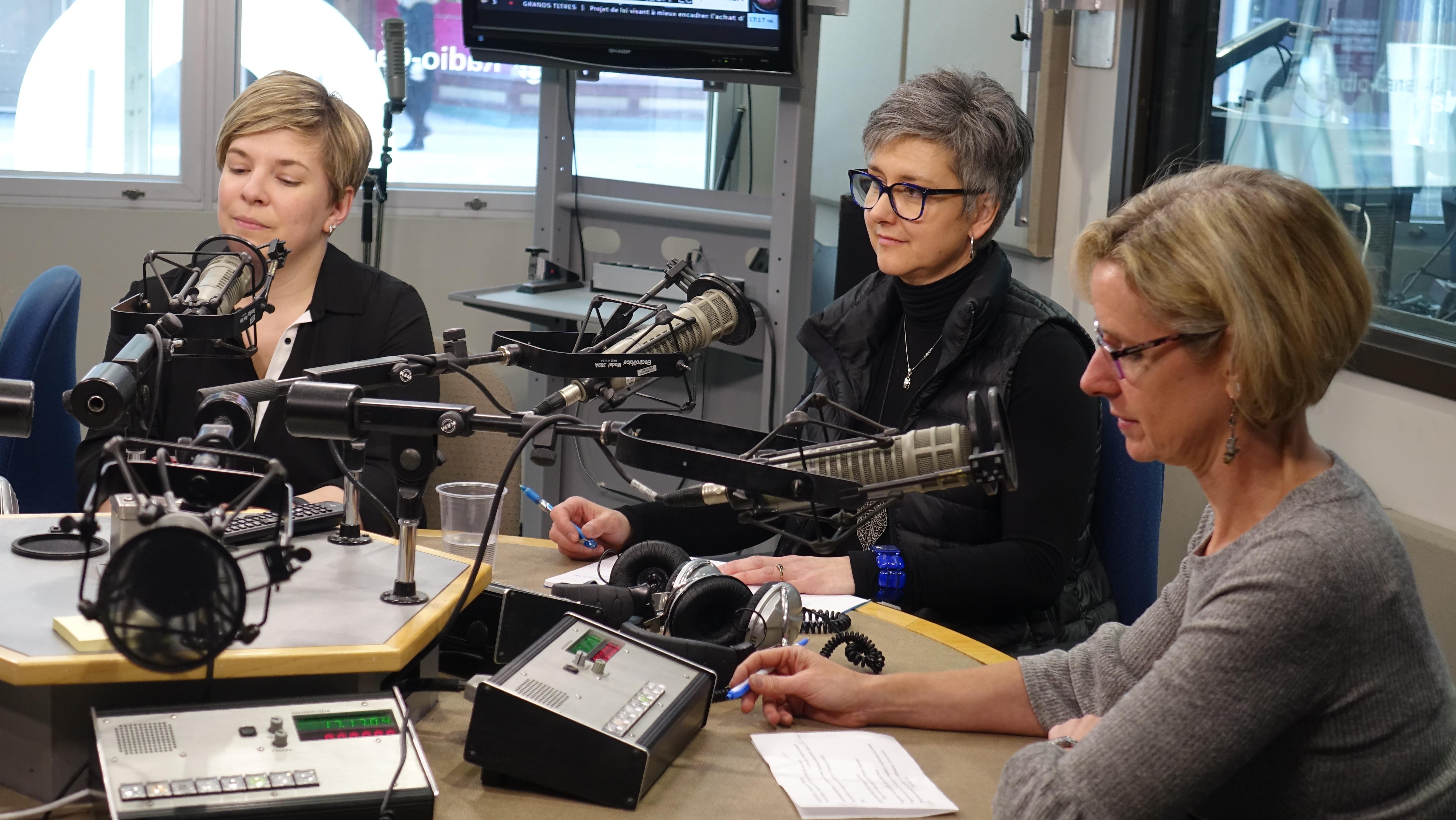 Trois femmes devant des micros dans un studio de Radio-Canada.