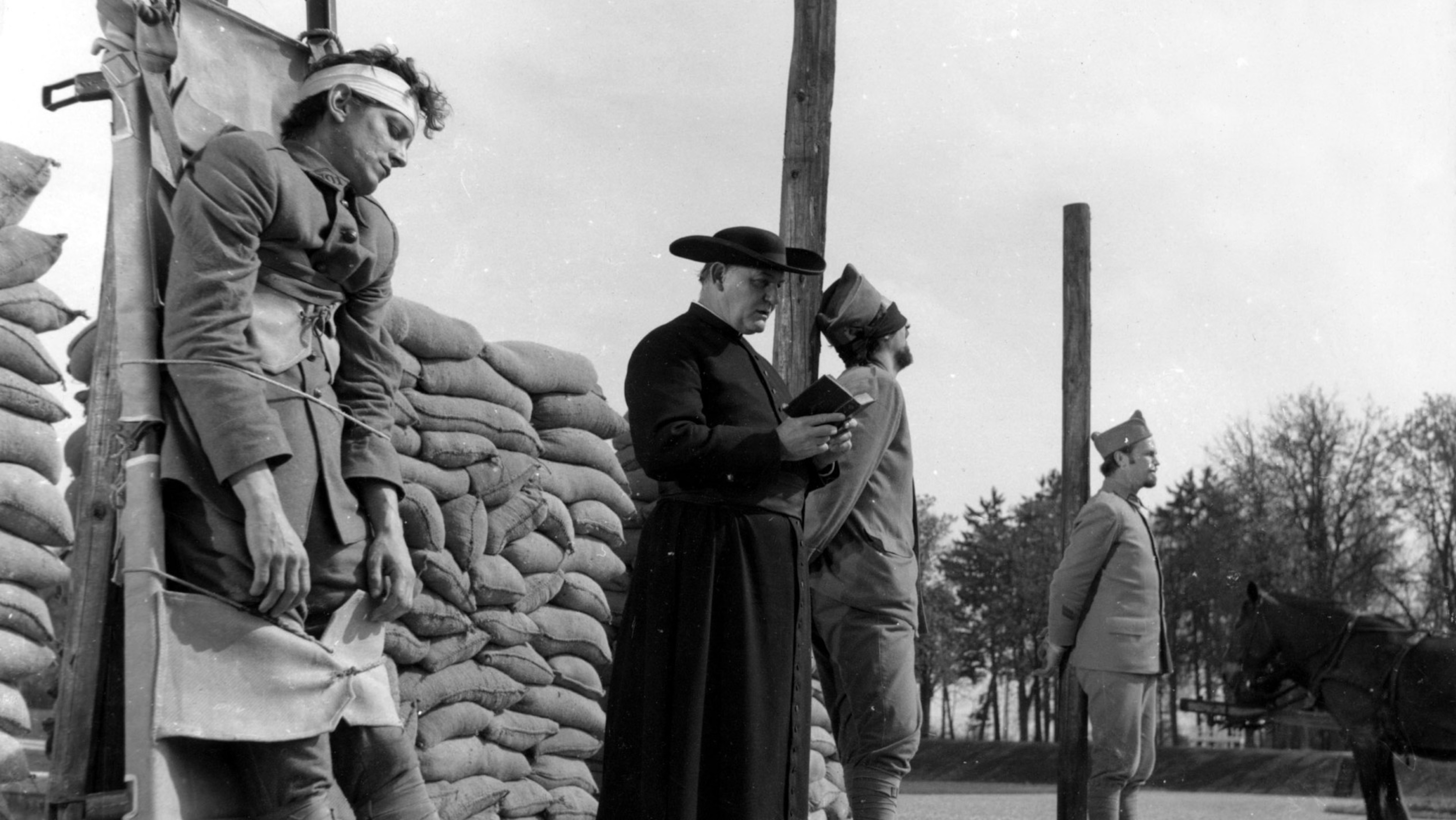 Un prêtre lit des prières à trois soldats sur le point d'être exécutés.