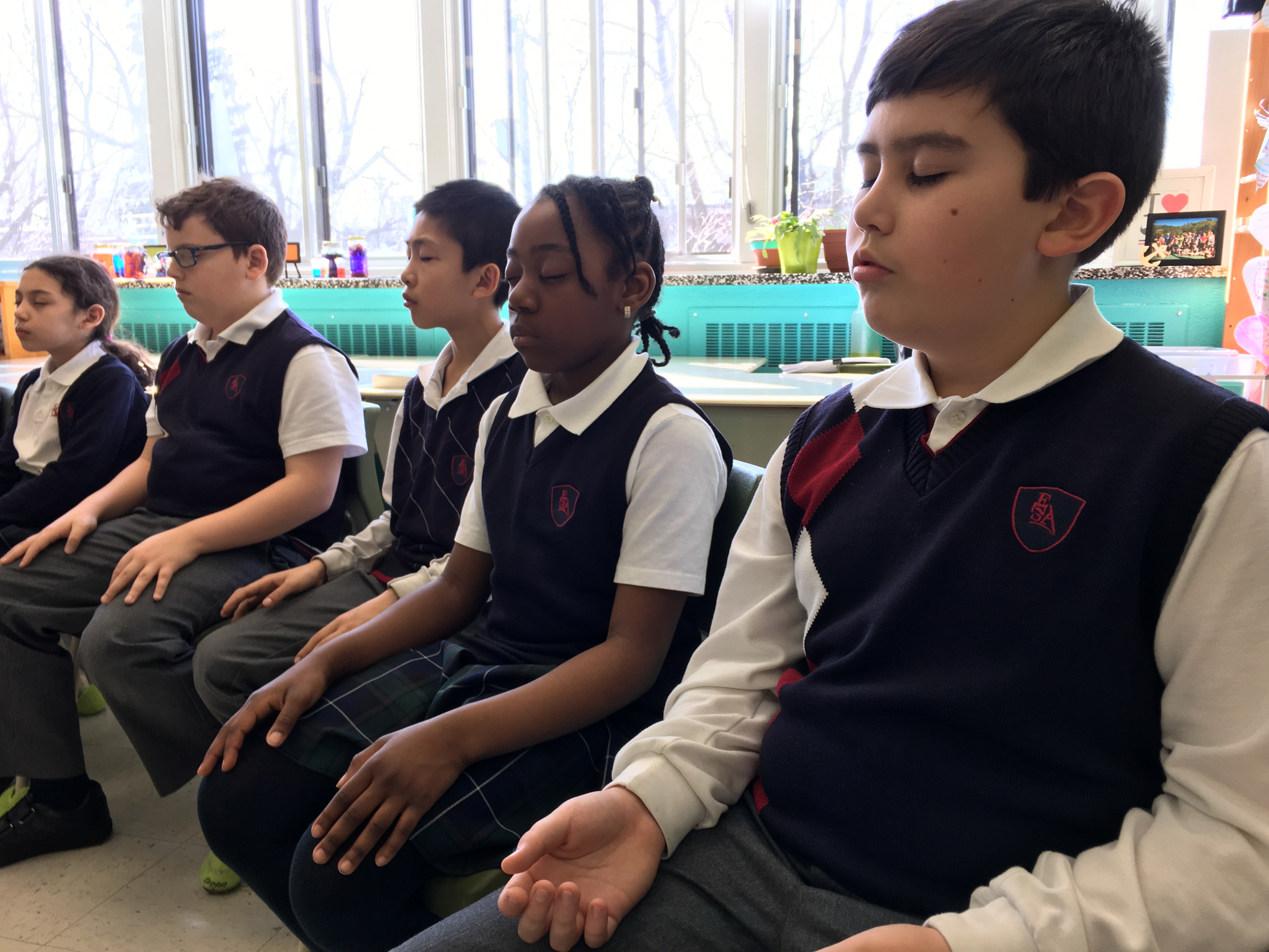 Des jeunes en train de méditer en classe.