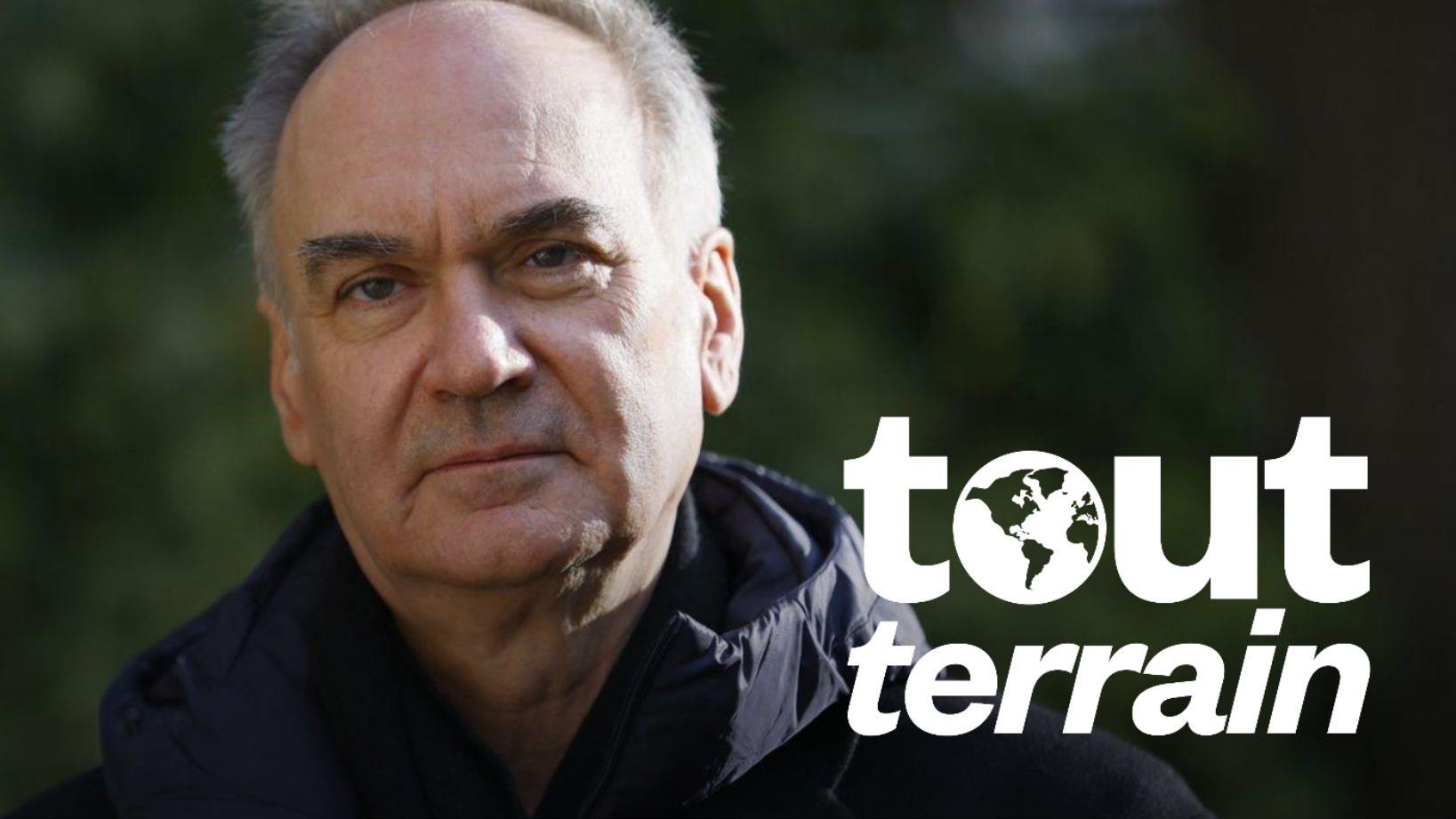 Portrait d'Herv&eacute; Le Tellier &agrave; l'ext&eacute;rieur, il porte un manteau noir.