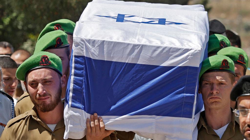 Militares israelíes transportan al hombro un ataúd.