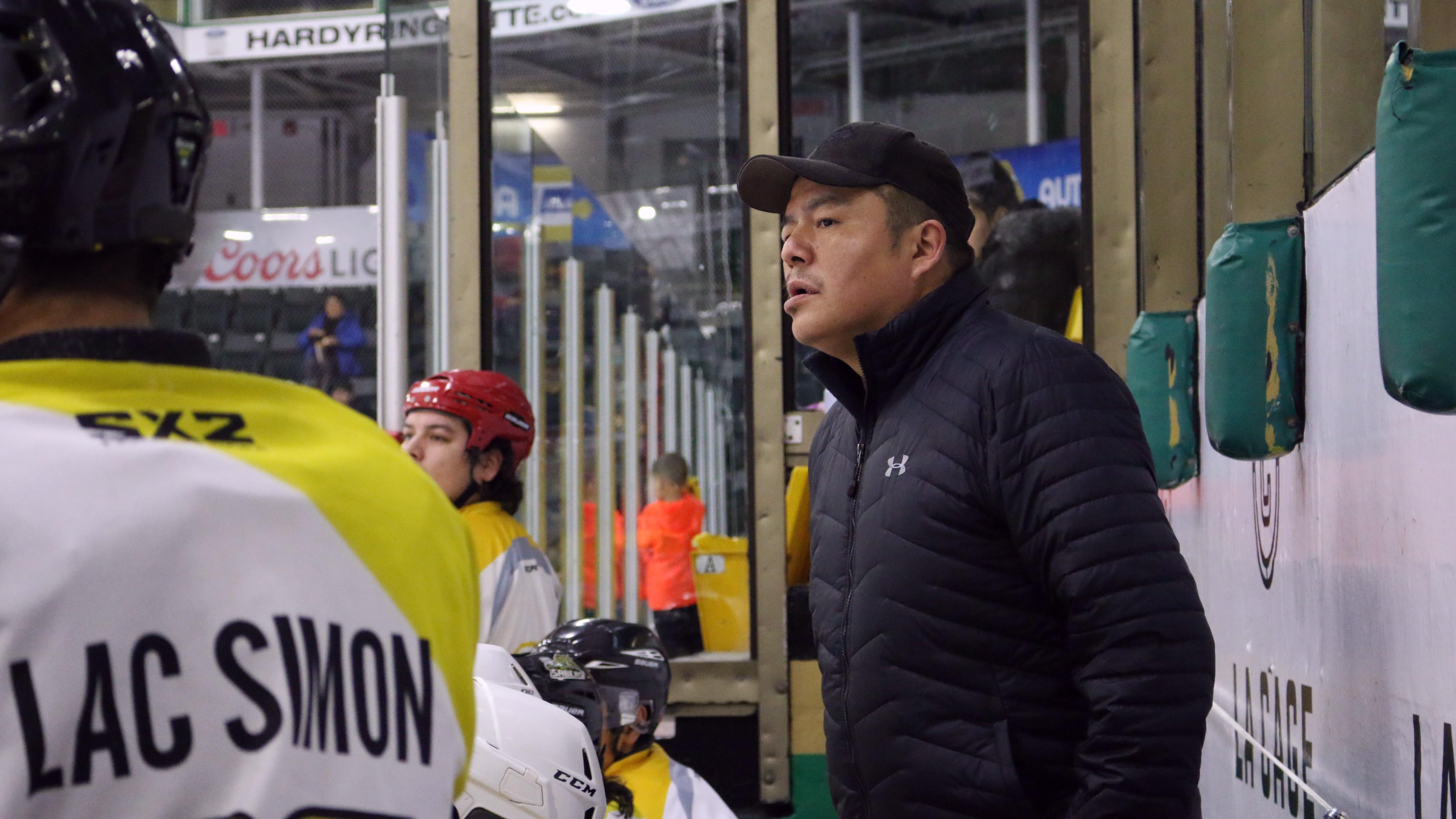 L’entraîneur Bryan Dumont observe avec attention un match de hockey entre son équipe, les Beavers de Lac-Simon, et les Wings de Waskaganish.
