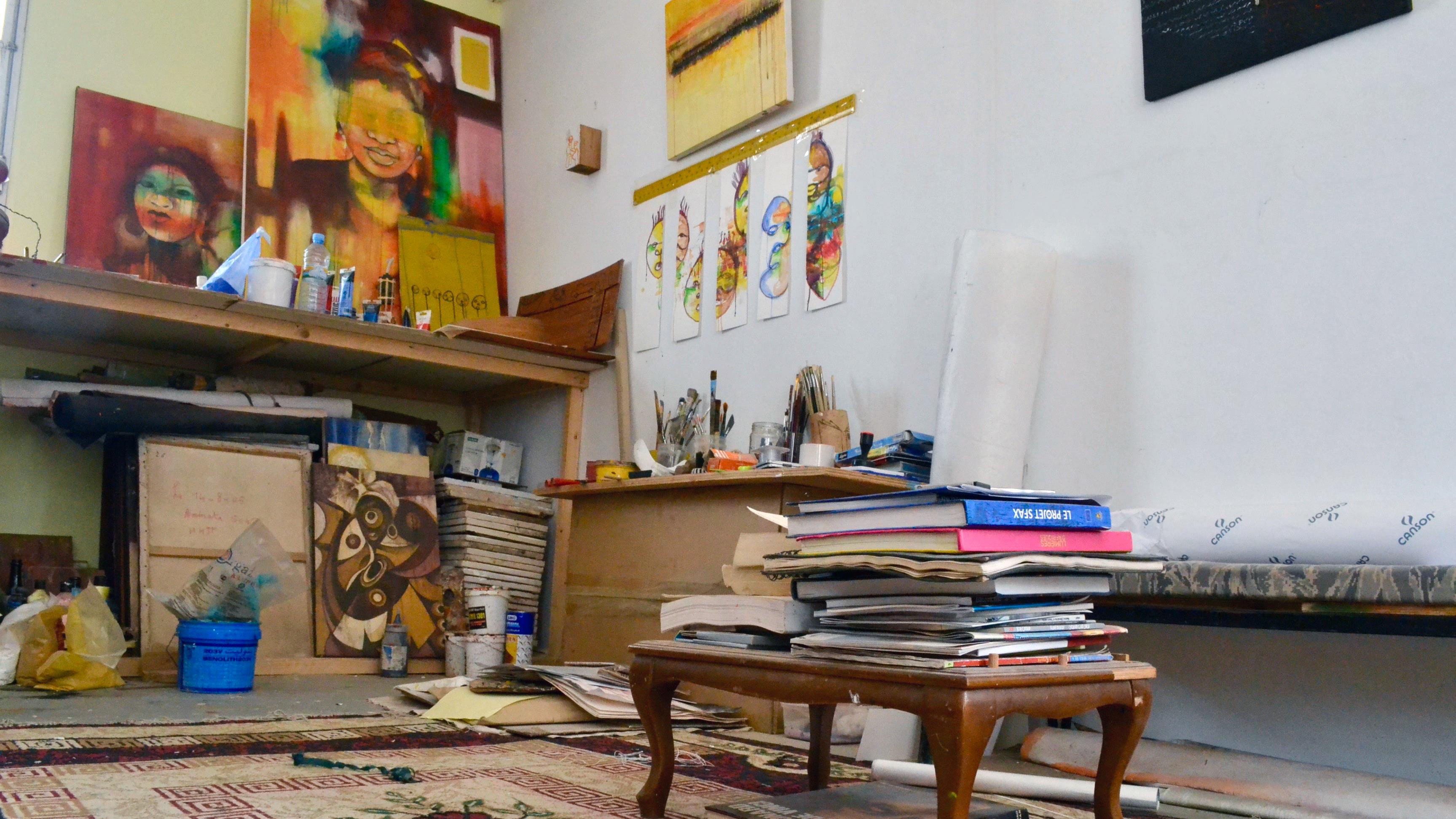 Des toiles inachevées représentant des visages de femmes dans l’atelier d'Amy Sow