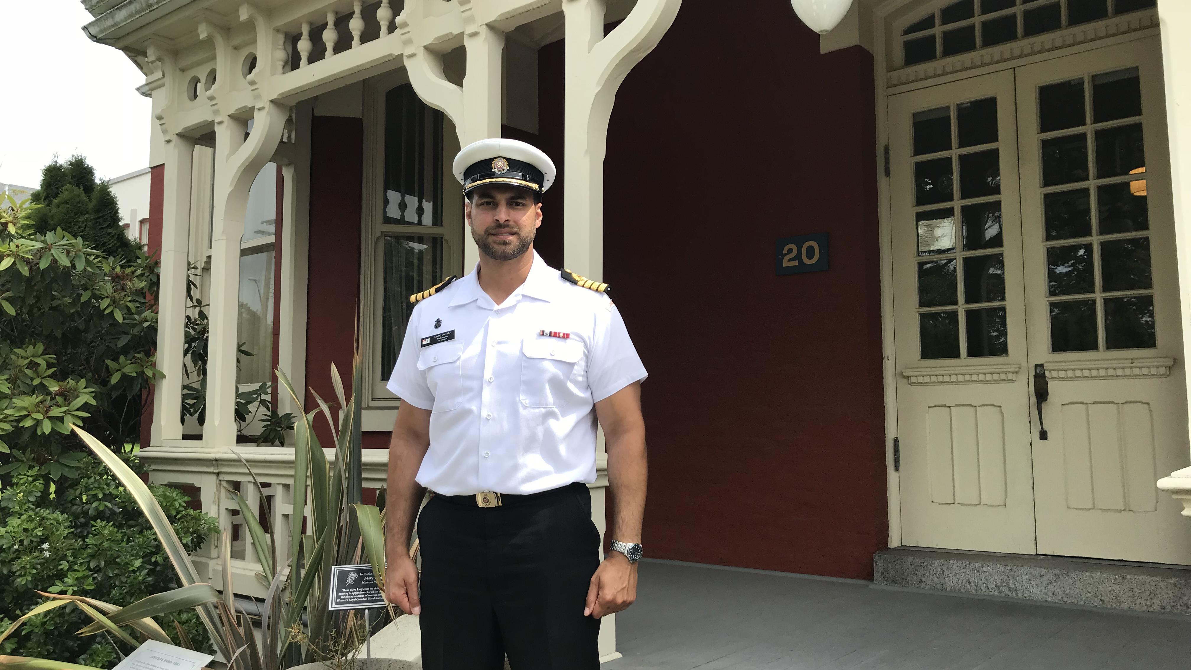 Le capitaine de vaisseau Sam Sader devant la petite école rouge.