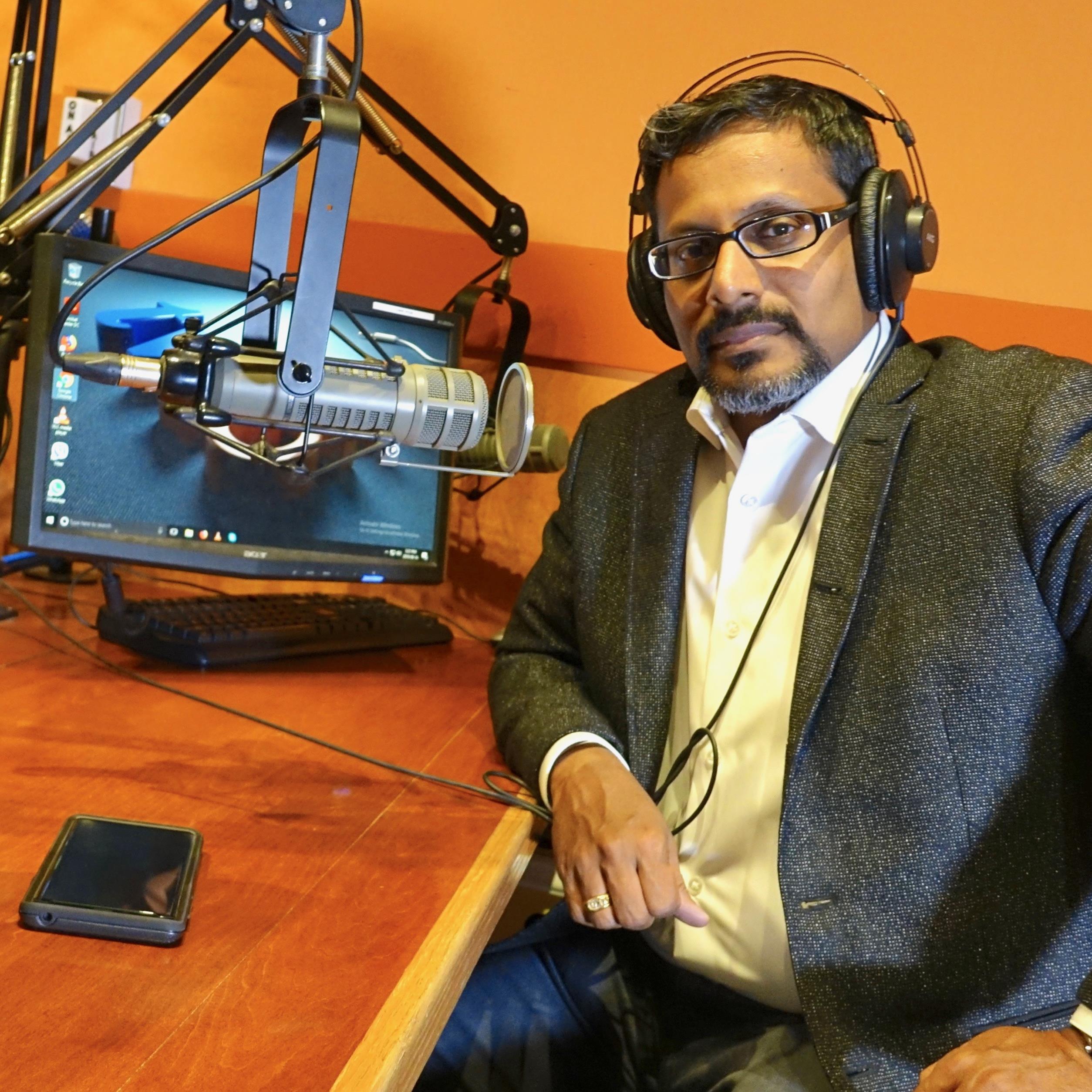 EL señor Pillai est sentado en un estudio de radio