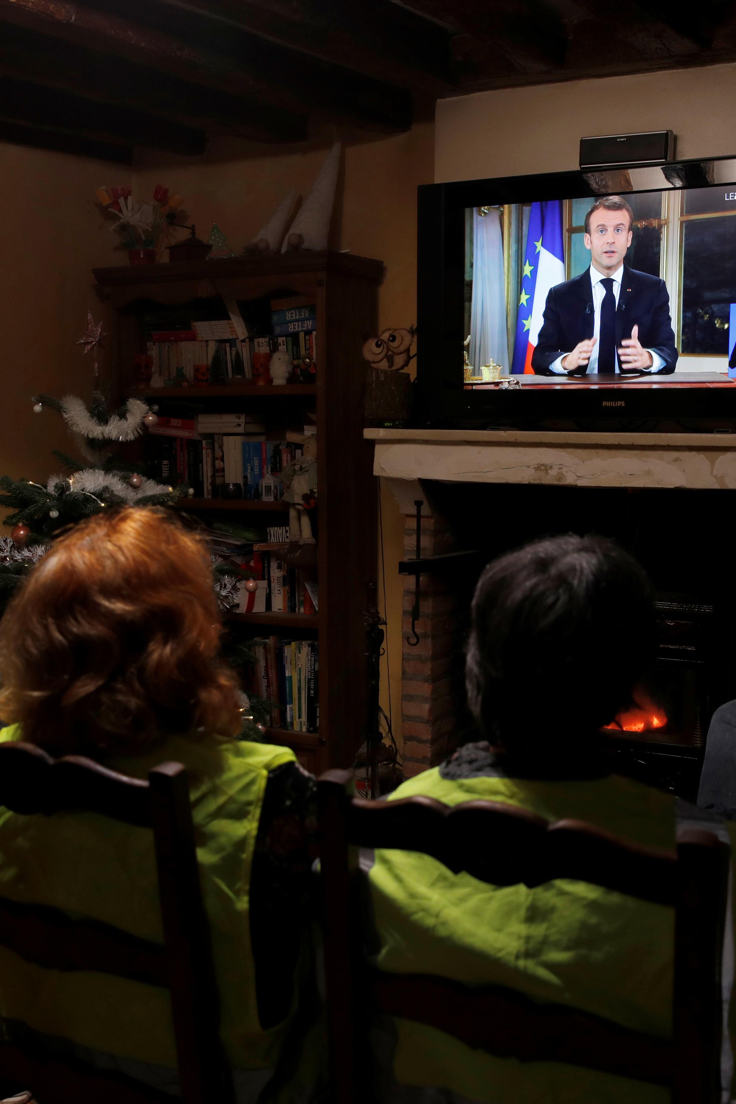Des gilets jaunes regardent le discours du président Emmanuel Macron, à Gaillon, en France, le 10 décembre 2018.