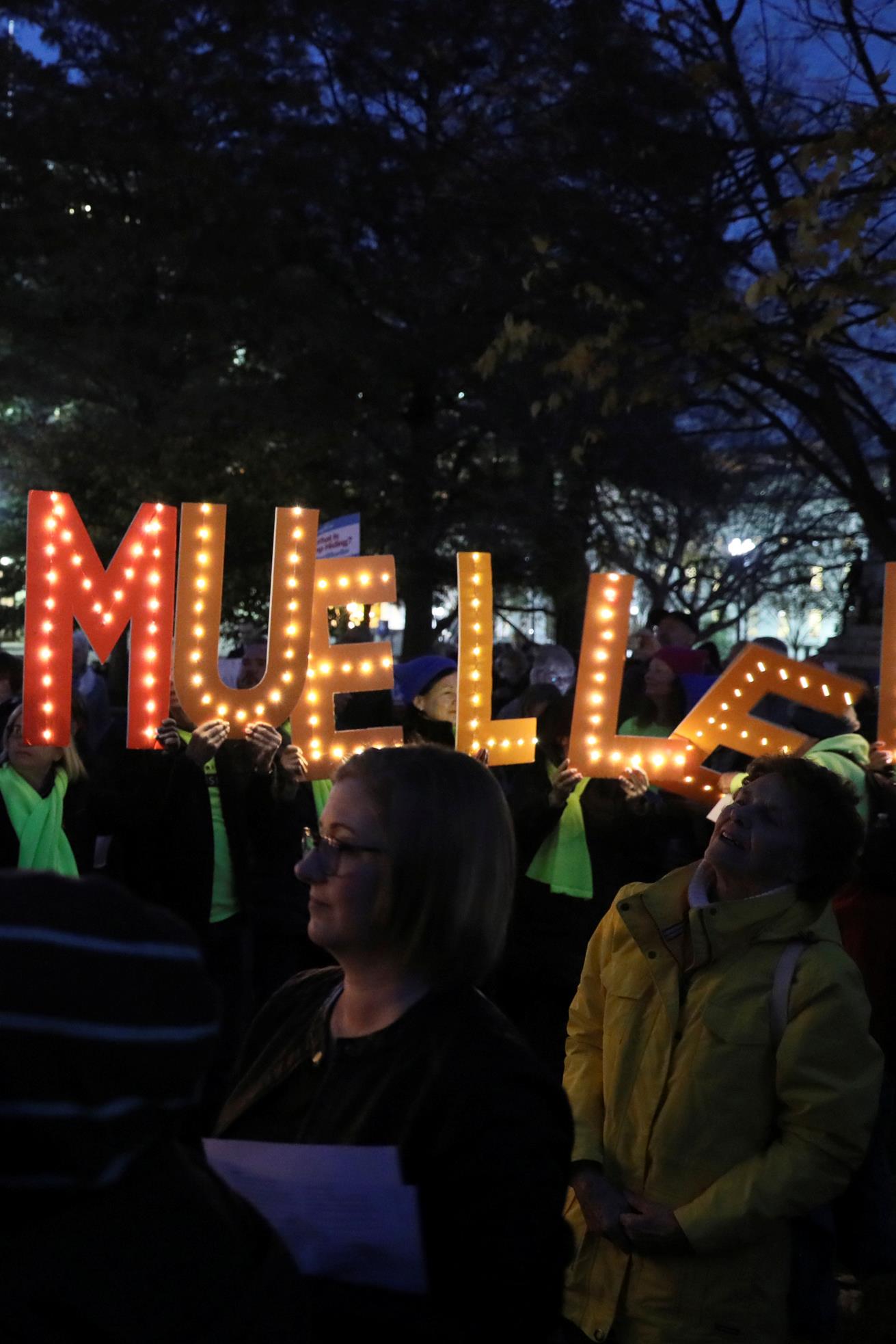 Des manifestants rasemblés devant la Maison-Blanche, le 8 novembre 2018, demandent au gouvernement américain de protéger l'enquête du procureur spécial Robert Mueller. Ils tiennent des lettres illuminées sur lesquelles est écrit : « Save Mueller » (Protégez Mueller).