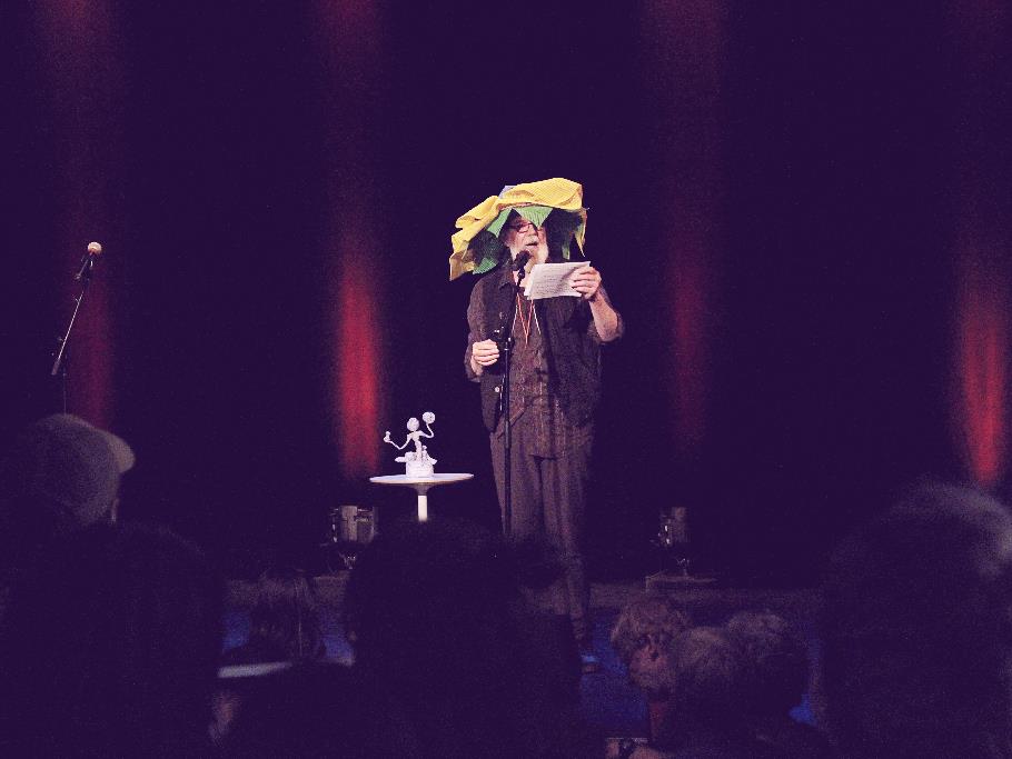 L'animateur de la soirée arborant son chapeau en fleur sur scène