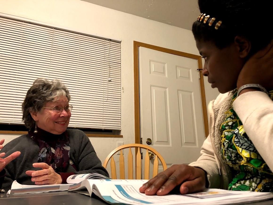 Kristin Freeman, left, helps Chantal Nyiramanza learn English.