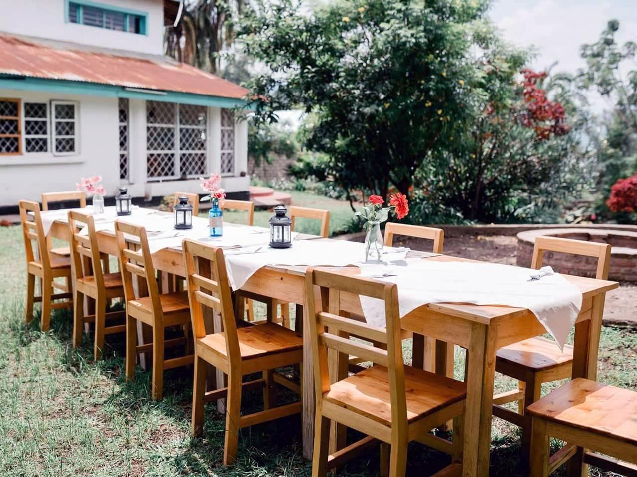Une longue table et des chaises installées sur le parterre.
